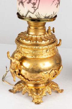 Two Similar Cupid Newel Post Oil Lamps with Burmese Shades