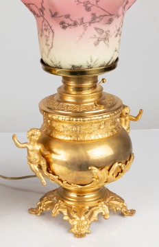 Two Similar Cupid Newel Post Oil Lamps with Burmese Shades