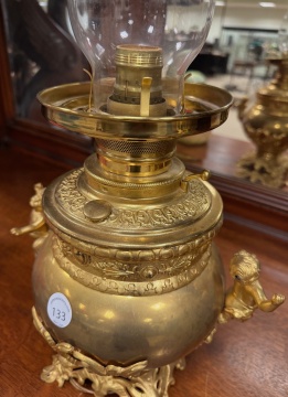 Two Similar Cupid Newel Post Oil Lamps with Burmese Shades